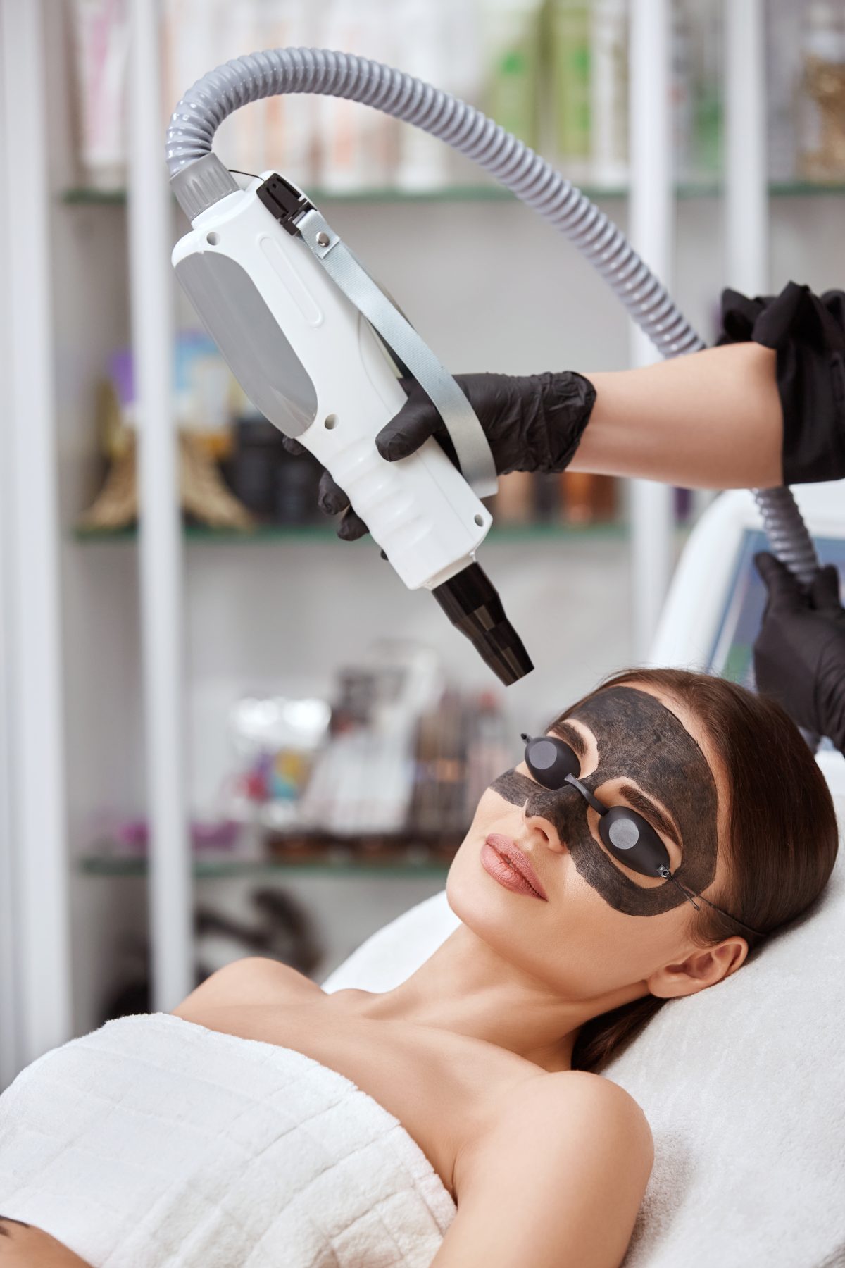 woman_with_carbon_mask_face_receiving_laser_procedures_black_glasses-1200x1800.jpg